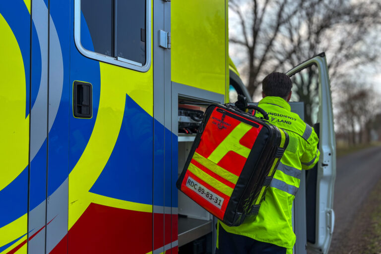 Ein Mitarbeiter des Rettungsdienstes hebt einen Notfallrucksack aus dem Rettungswagen